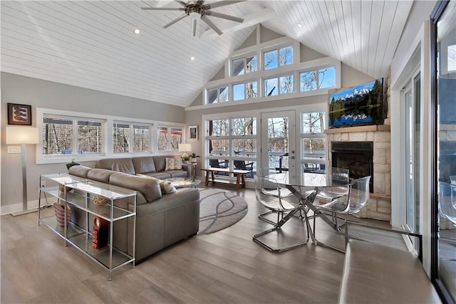 living room featuring high vaulted ceiling, a fireplace, wood finished floors, and a ceiling fan