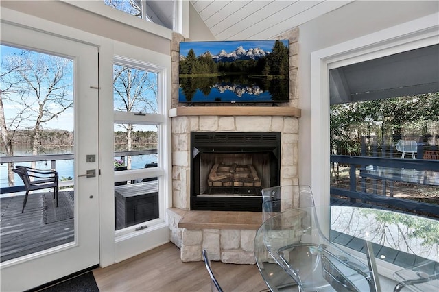 living room with a fireplace, lofted ceiling, and wood finished floors