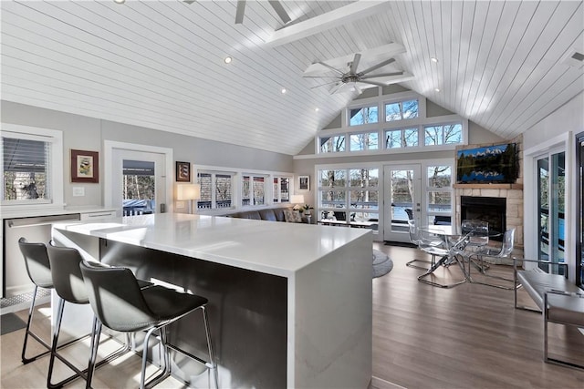 kitchen featuring a kitchen island, open floor plan, light countertops, wooden ceiling, and wood finished floors