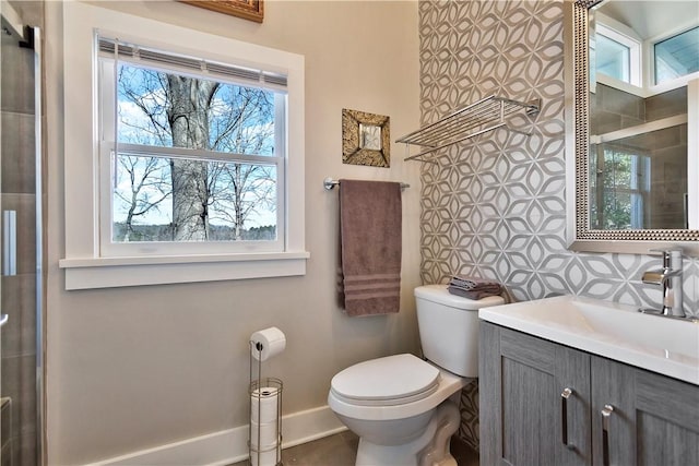 bathroom featuring toilet, vanity, and baseboards