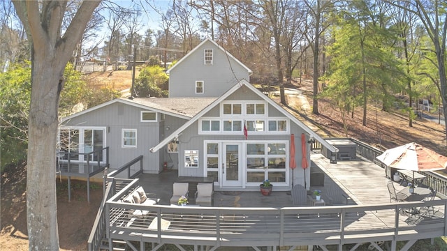 back of property featuring a wooden deck and roof with shingles