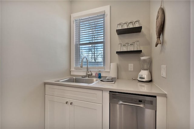 kitchen featuring a sink, open shelves, stainless steel dishwasher, white cabinets, and light countertops