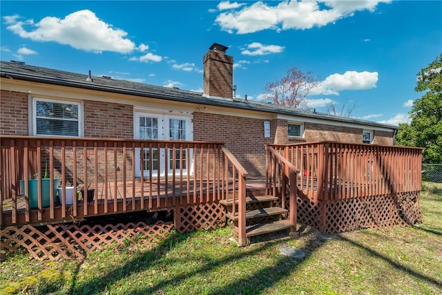 back of property with brick siding, a chimney, and a lawn