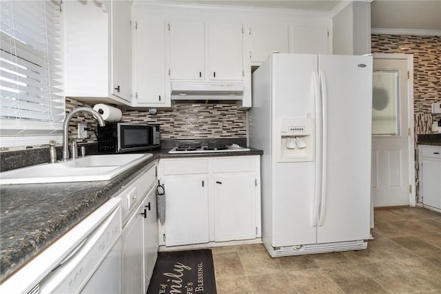 kitchen with white appliances, a sink, decorative backsplash, under cabinet range hood, and dark countertops