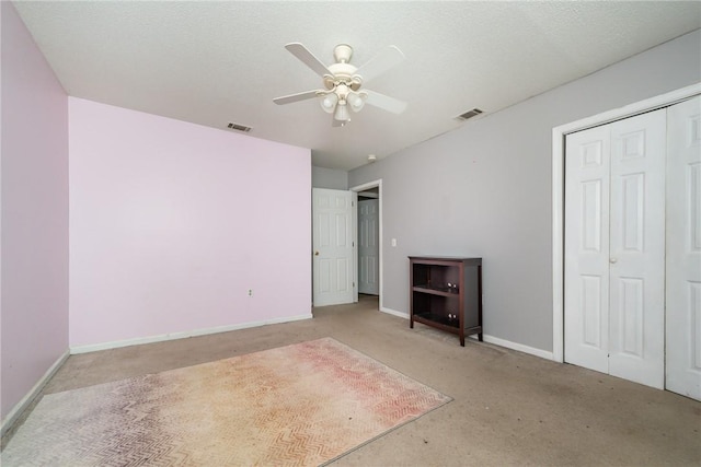 unfurnished bedroom featuring light carpet, visible vents, ceiling fan, and baseboards