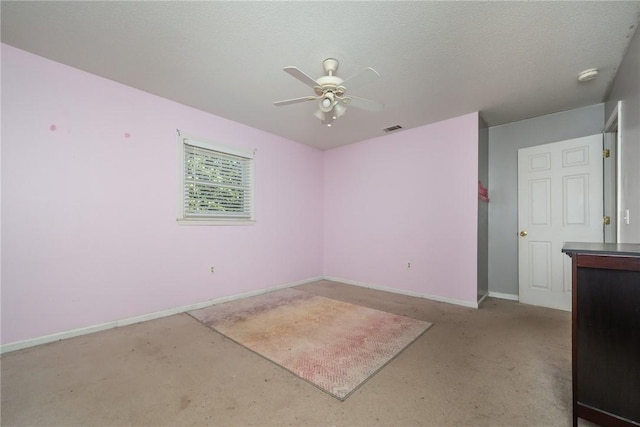 spare room with baseboards, visible vents, concrete floors, and ceiling fan