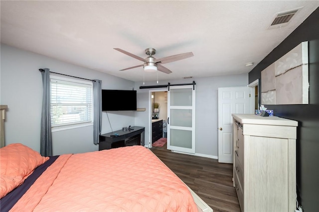 bedroom featuring visible vents, dark wood-style floors, a barn door, baseboards, and ceiling fan