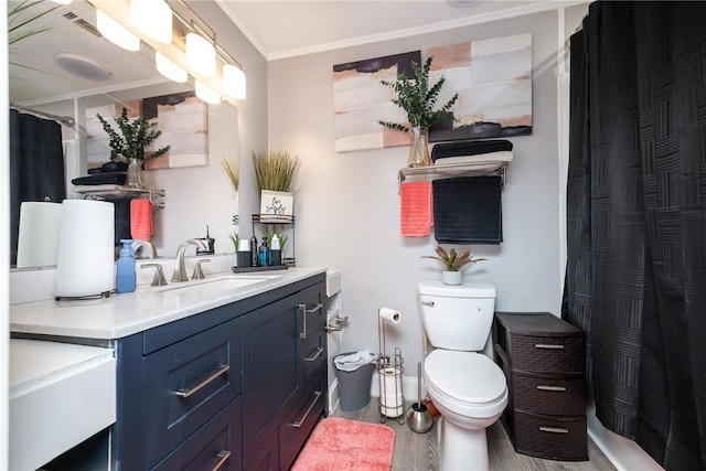 full bath with vanity, a shower with curtain, wood finished floors, crown molding, and toilet