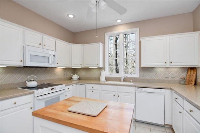 kitchen featuring a ceiling fan, a sink, white cabinetry, white appliances, and light tile patterned flooring