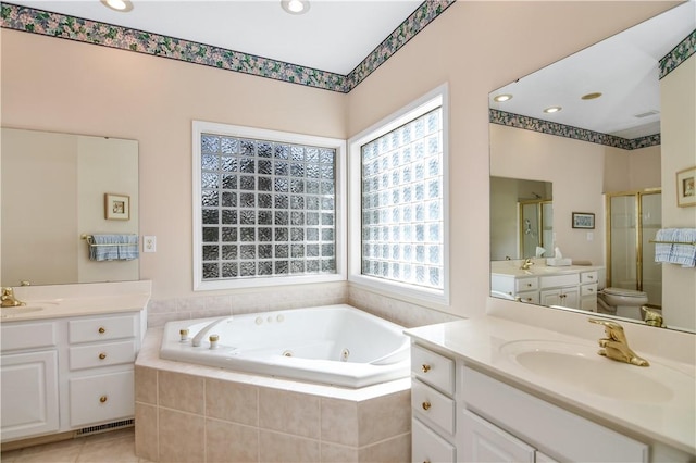 bathroom featuring tile patterned flooring, a shower stall, a tub with jets, and a sink