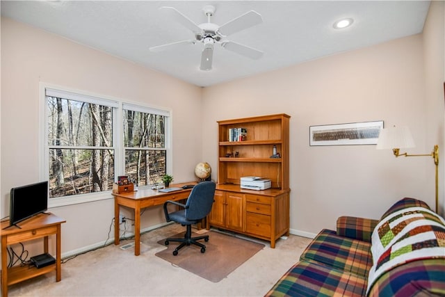 office with light colored carpet, a ceiling fan, and baseboards