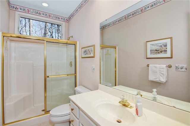 bathroom with vanity, a shower stall, and toilet