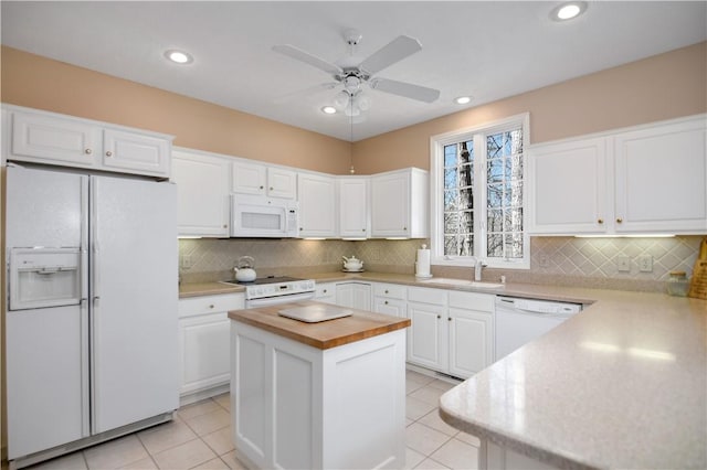 kitchen with white appliances, white cabinetry, wood counters, and ceiling fan