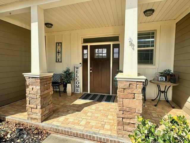 view of exterior entry with board and batten siding and a porch