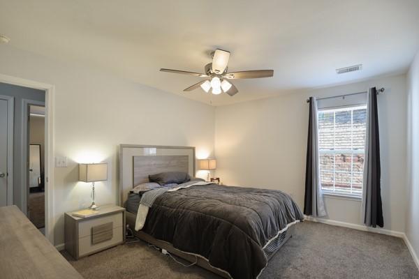 bedroom with visible vents, carpet flooring, baseboards, and ceiling fan