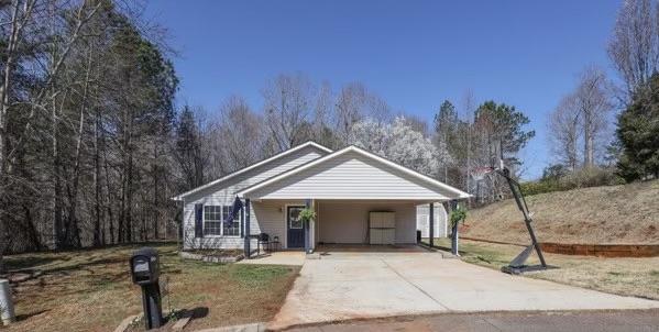 bungalow-style house with an attached carport and concrete driveway