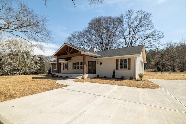 view of front of house with stucco siding and a chimney