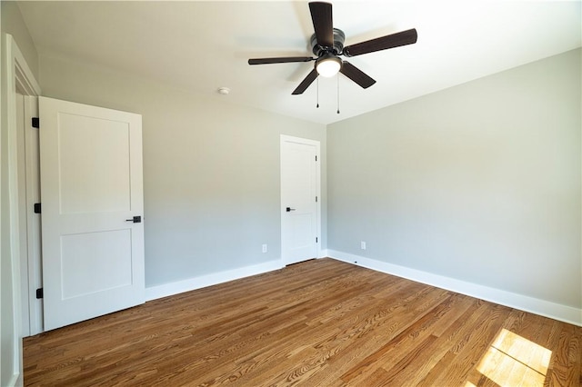 unfurnished bedroom with ceiling fan, baseboards, and wood finished floors