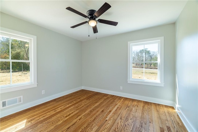 empty room with visible vents, a healthy amount of sunlight, and baseboards