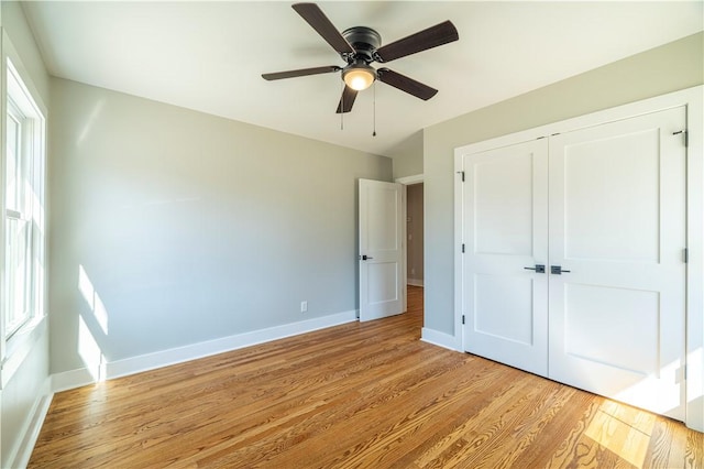 unfurnished bedroom with light wood finished floors, ceiling fan, a closet, and baseboards