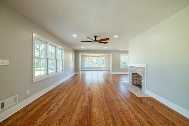 unfurnished living room with visible vents, wood finished floors, recessed lighting, a fireplace, and baseboards