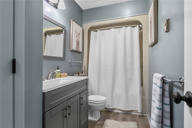 bathroom with vanity, toilet, wood finished floors, and shower / tub combo with curtain