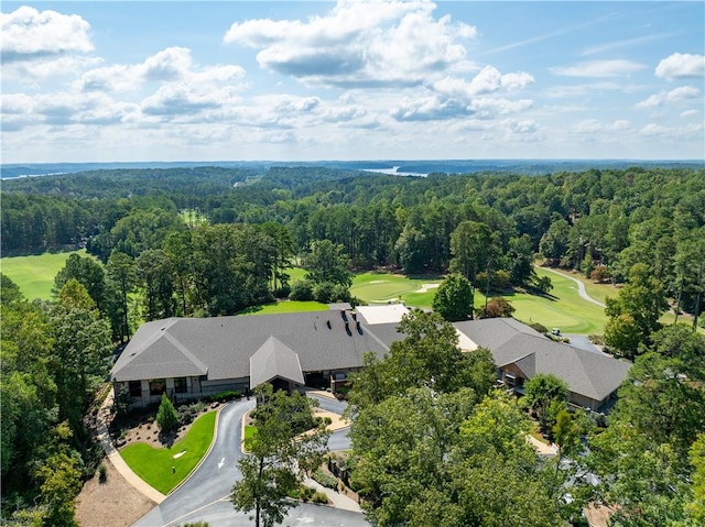 drone / aerial view featuring view of golf course and a wooded view