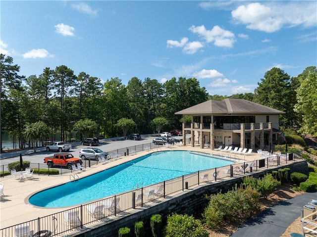 pool with a patio area and fence