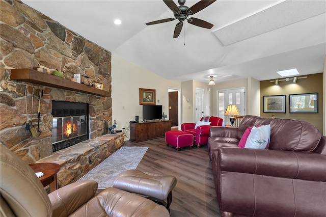 living room featuring vaulted ceiling, a fireplace, a ceiling fan, and wood finished floors