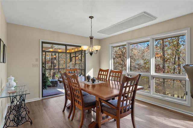 dining area featuring an inviting chandelier, baseboards, and wood finished floors