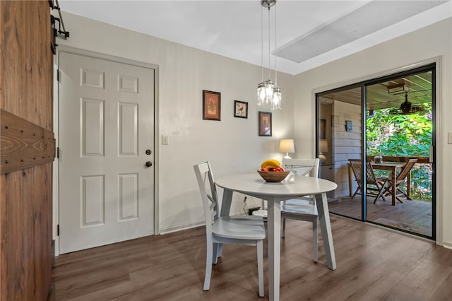 dining room with a notable chandelier, wood finished floors, and baseboards