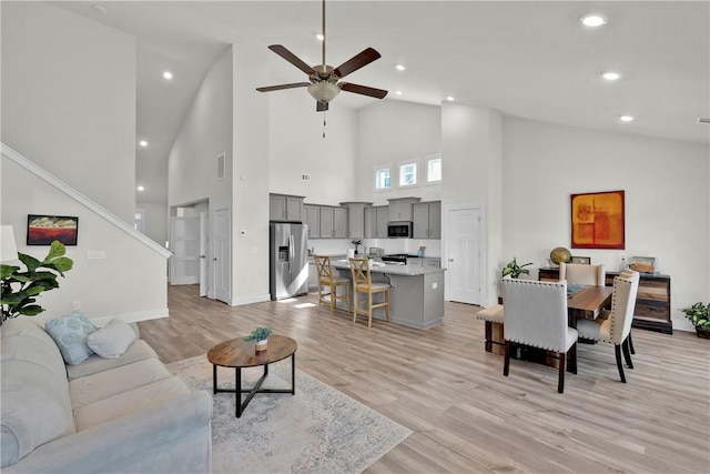 living area with a ceiling fan, visible vents, light wood-style flooring, recessed lighting, and stairs