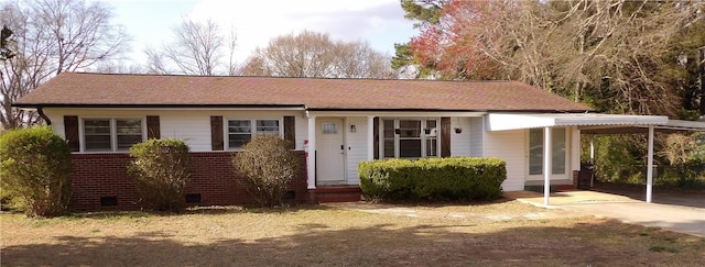 ranch-style house featuring a carport, driveway, and a shingled roof