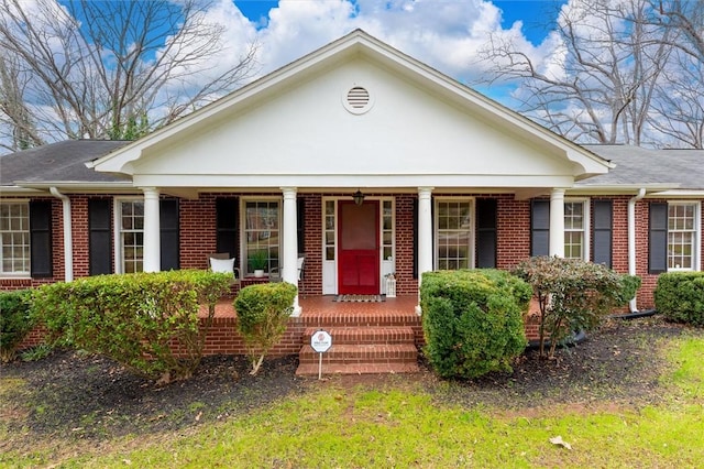 view of front facade with brick siding and covered porch