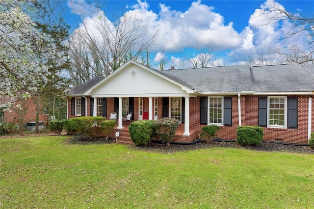 view of front of home with brick siding, a porch, a front yard, and roof with shingles