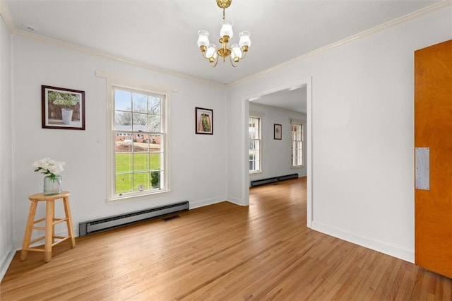 empty room with a chandelier, baseboard heating, light wood-type flooring, and ornamental molding