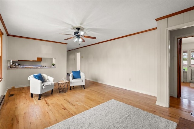 sitting room featuring baseboards, crown molding, a ceiling fan, and hardwood / wood-style flooring