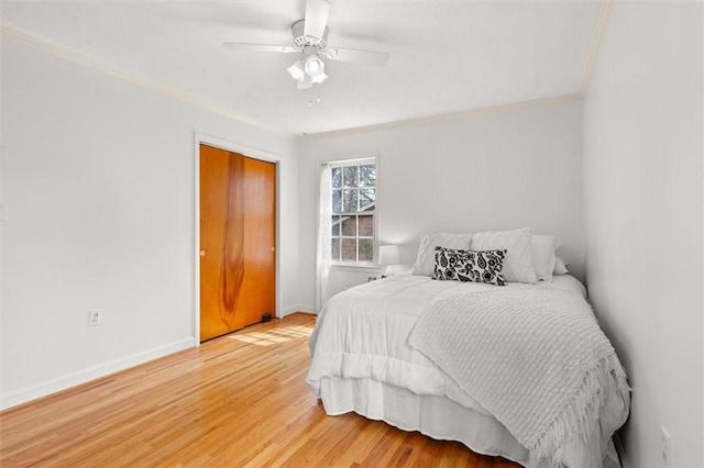 bedroom with ceiling fan, light wood-type flooring, baseboards, and ornamental molding