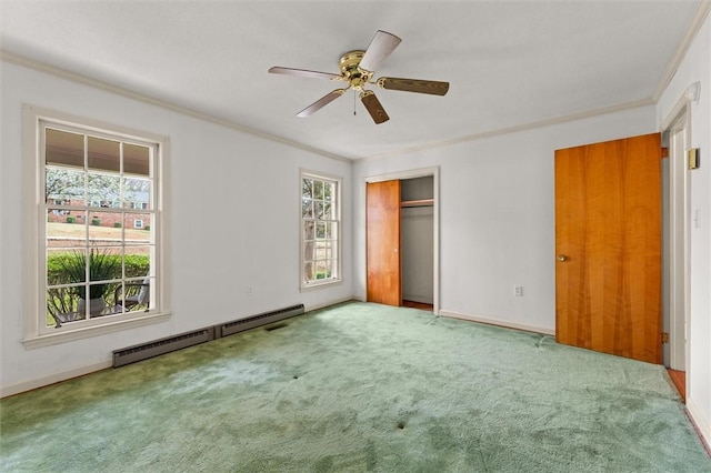 unfurnished bedroom featuring baseboards, a closet, a baseboard heating unit, crown molding, and carpet flooring