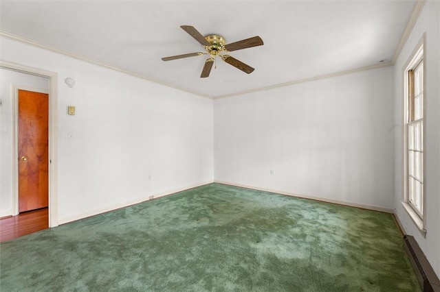 carpeted spare room with baseboards, a ceiling fan, and crown molding