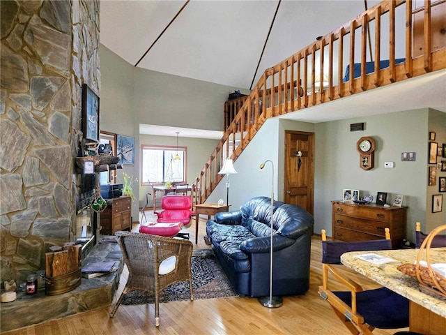 living area with stairway, a high ceiling, and wood finished floors