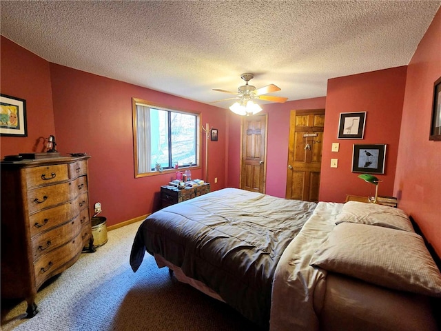 bedroom featuring a textured ceiling, light colored carpet, baseboards, and ceiling fan