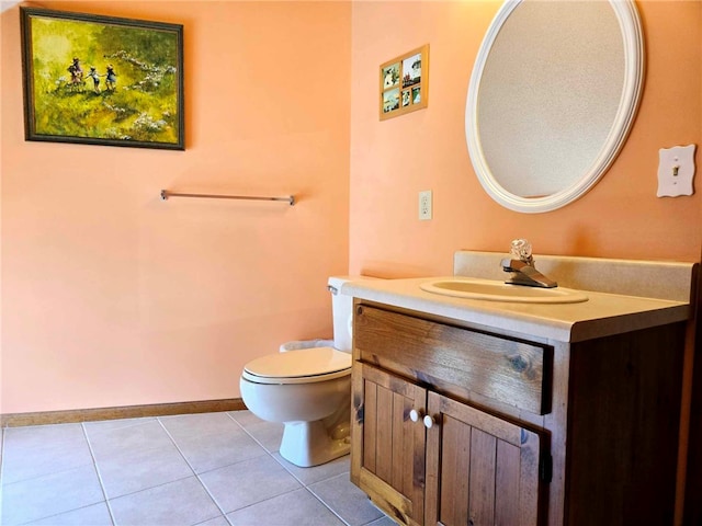 half bathroom with tile patterned floors, baseboards, toilet, and vanity