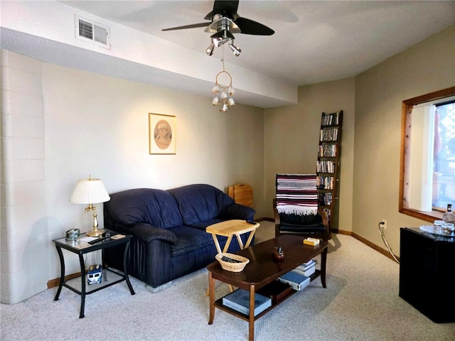 living area featuring visible vents, baseboards, ceiling fan, and carpet flooring