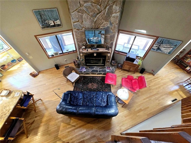 living room with visible vents, a healthy amount of sunlight, a fireplace, and wood finished floors