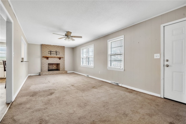 unfurnished living room featuring visible vents, crown molding, carpet, a textured ceiling, and a ceiling fan