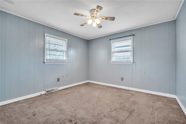 unfurnished room with visible vents, a ceiling fan, a healthy amount of sunlight, and carpet flooring