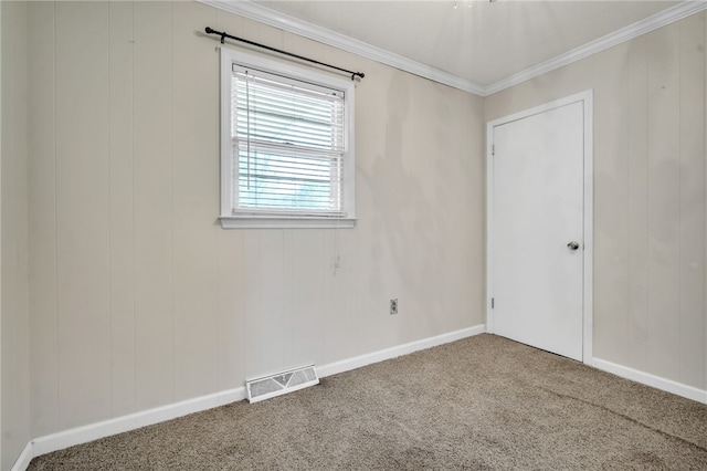 carpeted spare room featuring baseboards, visible vents, and ornamental molding