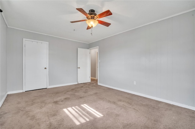 unfurnished bedroom featuring carpet flooring, a ceiling fan, baseboards, and ornamental molding