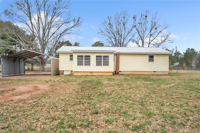 back of property featuring a detached carport, a lawn, metal roof, crawl space, and driveway